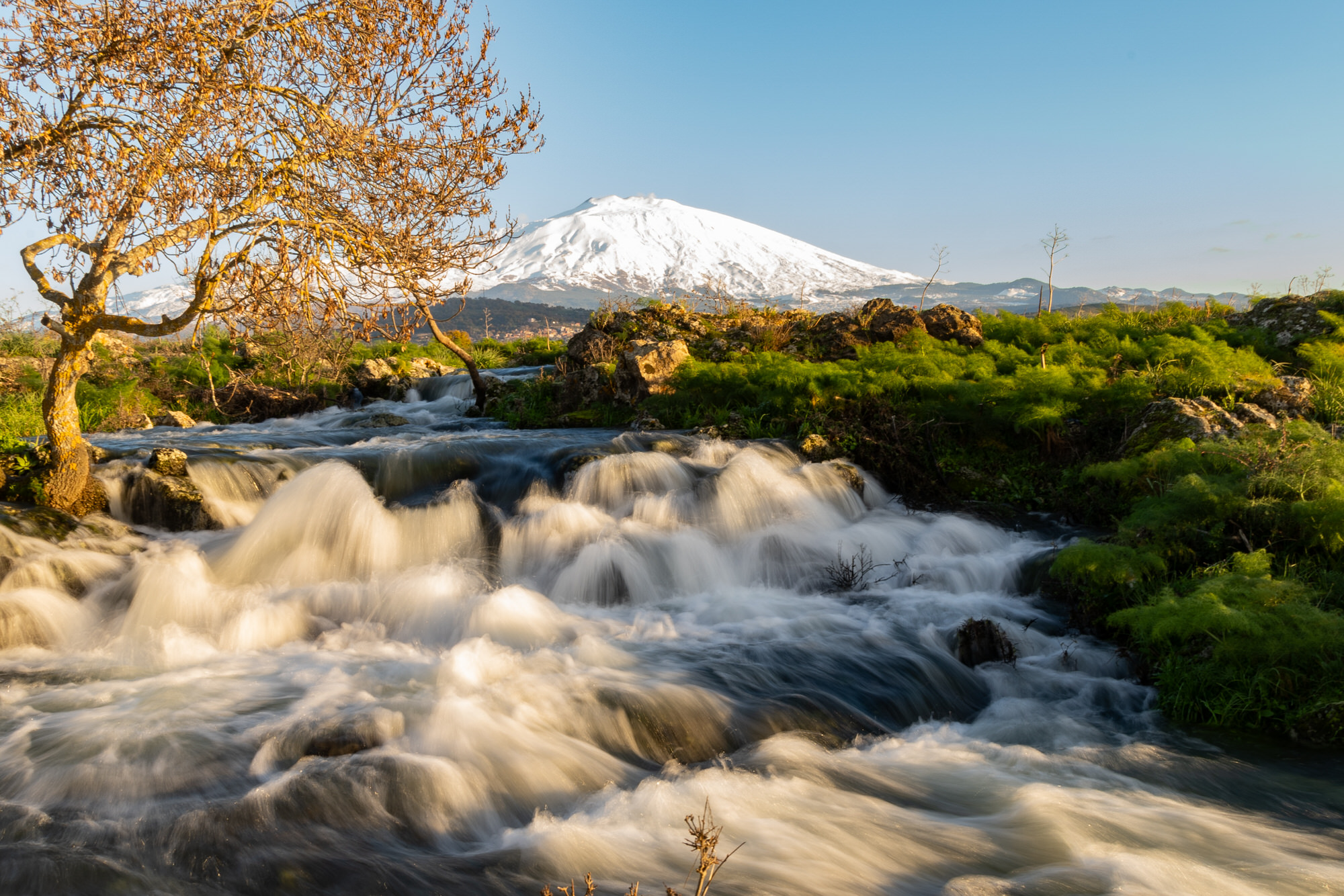 A seasonal river flows under the massive snowcovered Etna volcano. Favare Santa Venera A seasonal river flows under the massive snowcovered Etna volcano. Favare Santa Venera
